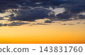 Golden sunset sky fading to twilight with dark clouds 143831760