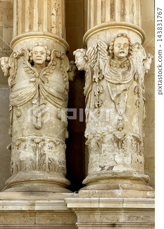 Baroque columns with cherub sculptures and religious carvings 143831767