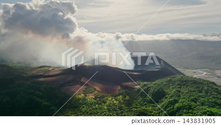 Aerial view Mount Yasur, an active stratovolcano on Tanna Island, Vanuatu, continuously emits white smoke and ash from its crater, creating a dramatic natural landscape of lush tropical vegetation Aerial view Mount Yasur, an active stratovolcano on Tanna Island, Vanuatu, continuously emits white smoke and ash from its crater, creating a dramatic natural landscape of lush tropical vegetation 143831905
