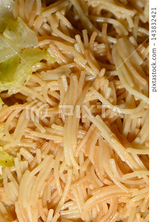 A detailed close-up photograph of a ramen noodle dish with overlapping long noodles in a creamy light yellow sauce 143832421