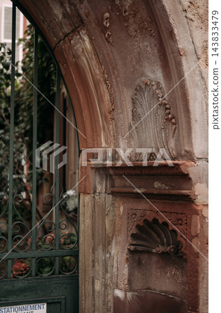 Historic sandstone archway with ornate wrought iron gate in Strasbourg, France 143833479