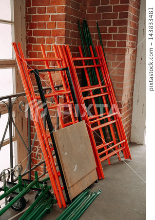 Construction scaffolding components stored indoors during building renovation 143833481