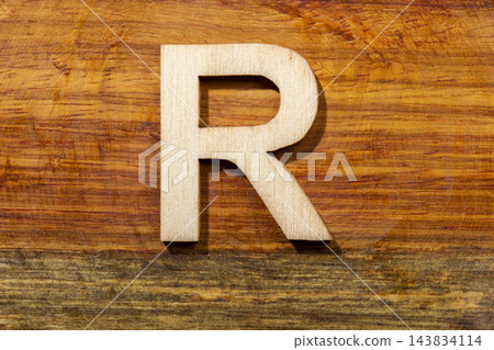 Wooden letters R on wooden background, top view Wooden letters R on wooden background, top view 143834114