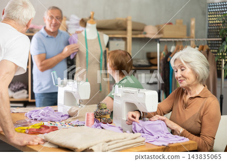 Mature women sew and talking, other senior student work with mannequin Mature women sew and talking, other senior student work with mannequin 143835065