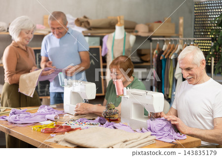 Some people communicate and discuss pattern, while others sew using sewing machine at lesson Some people communicate and discuss pattern, while others sew using sewing machine at lesson 143835179