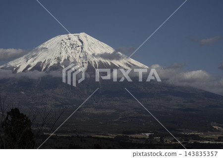 白雪皚皚的富士山,籠罩在藍天白雲之中。 白雪皚皚的富士山,籠罩在藍天白雲之中。 143835357