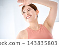 A woman with her arms raised above her head and a big smile on her face. 143835803