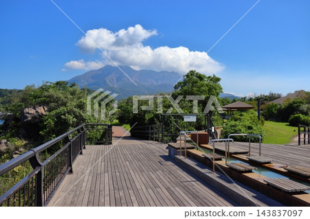 從櫻島熔岩渚公園的足浴池可以看到櫻島火山噴發出縷縷青煙（鹿兒島縣鹿兒島市） 143837097