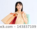A smiling woman carrying many paper bags 143837109