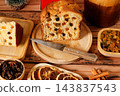 Sliced italian panettone, filled with raisins and candied fruit, on bamboo boards atop a rustic wooden table. 143837543