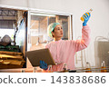 Quality inspector a woman carefully examines beverage bottles on a conveyor 143838686