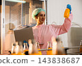 Quality inspector a woman carefully examines beverage bottles on a conveyor 143838687