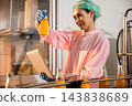Quality inspector a woman carefully examines beverage bottles on a conveyor 143838689