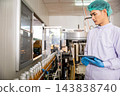Quality control officer inspects beverage bottling factory line with tablet ensuring top-notch quality 143838740