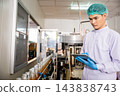 Quality control officer inspects beverage bottling factory line with tablet ensuring top-notch quality 143838743