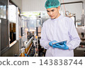 Quality control officer inspects beverage bottling factory line with tablet ensuring top-notch quality 143838744