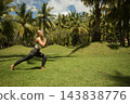 Fitness enthusiast engaging in lunges on lush green grass 143838776