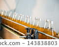 Basil or chia seed beverages with pomegranate undergo quality filling into transparent bottles 143838803