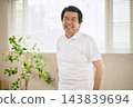 A smiling senior man standing by the window. 143839694
