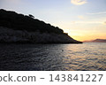 Rocky Mediterranean coastline at golden hour sunset with calm sea 143841227