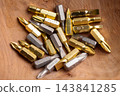 Collection of screwdriver bits scattered in brown wooden tray close up 143841285