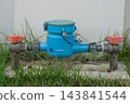 Water meter for measuring water usage is installed in front of the house. 143841544