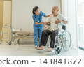 Nurse assisting elderly man in wheelchair at healthcare facility for support 143841872