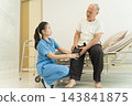 Nurse assisting senior man with knee evaluation in healthcare setting 143841875