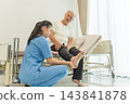 Nurse examining senior man's injured foot in hospital room for recovery support 143841878