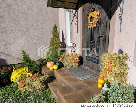 Autumn entrance decor pumpkins, a wreath, and hay bales Autumn entrance decor pumpkins, a wreath, and hay bales 143842189