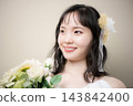 A young Japanese woman in her 20s, wearing a wedding dress and holding a bouquet, is a bride at a wedding and bridal event. 143842400