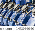 Fuel injectors and wiring mounted on a blue engine assembly on a factory production line 143844040