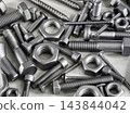 Assorted steel bolts, screws, nuts, and threaded fasteners arranged in a pile 143844042