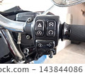 Right side motorcycle handlebar switch assembly featuring hazard lights start button and ignition kill switch mounted on chrome touring bar. 143844086