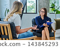 Middle aged professional female psychologist, counselor working with young woman 143845293