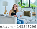 Young smiling student female study at home on couch with books, textbooks 143845296