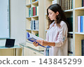 Portrait of teenage beautiful girl high school student reading textbook in library classroom 143845299