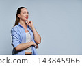 Thoughtful woman touching chin looking aside in studio gray backdrop shot 143845966