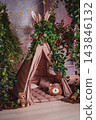 Children's play area in eco style with a fabric tent and decorative plants 143846132