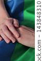 Vertical video. Close up lesbian couple in love holding hands on rainbow flag. Lgbt family holding hands outside. Woman relationship, lgbt family concept. 143848310