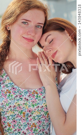 Vertical video. Lesbian couple closeup spending romantic time together standing on street. Vertical video. Lesbian couple closeup spending romantic time together standing on street. 143848318