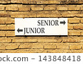 Senior or junior words symbol. Concept words Senior Junior on beautiful white sign plate. Beautiful brick wall background. Business and senior or junior concept. Copy space. 143848418