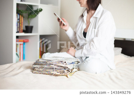 Woman choosing digital information over old newspapers 143849276