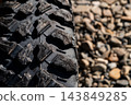 Close-up of off-road tire tread on gravel 143849285