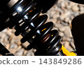 Close up of black vehicle shock absorber and spring 143849286