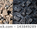 Close-up of off-road vehicle tire tread with stones 143849289