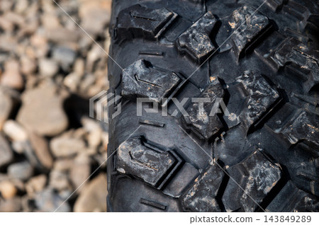 Close-up of off-road vehicle tire tread with stones Close-up of off-road vehicle tire tread with stones 143849289