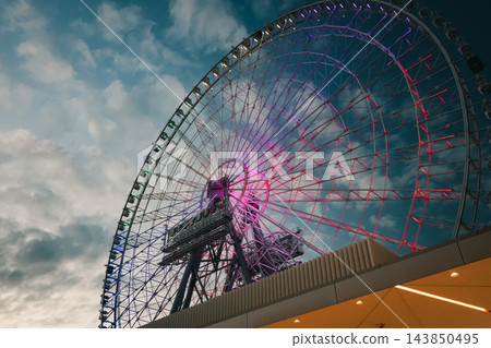 傍晚的天空景色壯麗,摩天輪的燈光也閃閃發光。 傍晚的天空景色壯麗,摩天輪的燈光也閃閃發光。 143850495