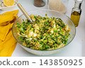 Quinoa, green peas, arugula, cauliflower, broccoli, and liver pate are served in a glass bowl on a kitchen counter for breakfast 143850925