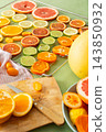 Citrus fruits are being prepared for Christmas drying. Different types of citrus are placed on a cutting board and drying rack in a home kitchen. The scene shows a festive activity 143850932
